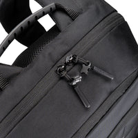 Close-up of a black backpack zipper with brand logo on a white background