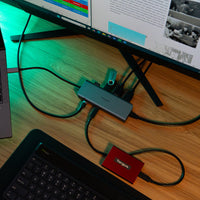 Computer setup with multiple devices and cables on a wooden desk