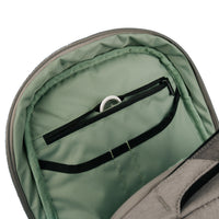 Close-up of the interior of a gray backpack showing a sage green padded compartment with a black zipper pocket and elastic band.